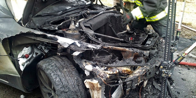 In this Wednesday, Nov. 6, 2013 photo provided by the Tennessee Highway Patrol, emergency workers respond to a fire on a Tesla Model S electric car in Smyrna, Tenn. Spokeswoman Liz Jarvis Shean says Tesla has sent a team to Tennessee to investigate the fire. Two other Model S cars have caught fire in the past five weeks, one near Seattle and the other in Mexico. (AP Photo/Tennessee Highway Patrol)
