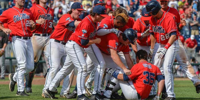 Mississippi players celebrate their 2-1 win over Texas Tech with teammate John Gatlin (36), who hit the single that scored Aaron Greenwood in the ninth inning, in an NCAA baseball College World Series elimination game in Omaha, Neb., Tuesday, June 17, 2014. (AP Photo/Ted Kirk)