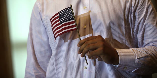 WASHINGTON, DC - JULY 03:  A new U.S. citizen holds a U.S. flag during a naturalization ceremony at the Treasury Department July 3, 2013 in Washington, DC. More than 7,800 people will become citizens at more than 100 special ceremonies, as part of the United States Citizenship and Immigration Services' (USCIS) annual celebration of Independence Day, across the country and around the world from July 1 to July 5.  (Photo by Alex Wong/Getty Images)