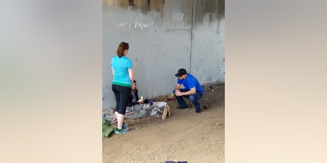 Veteran Kyle Cornwell and a volunteer speaking with a homeless veteran.