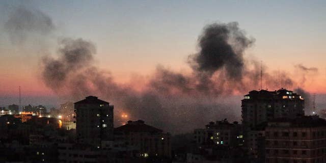 Smoke from fires caused by Israeli strikes, rises over Gaza City, Sunday, Aug. 10, 2014. (AP Photo/Lefteris Pitarakis)
