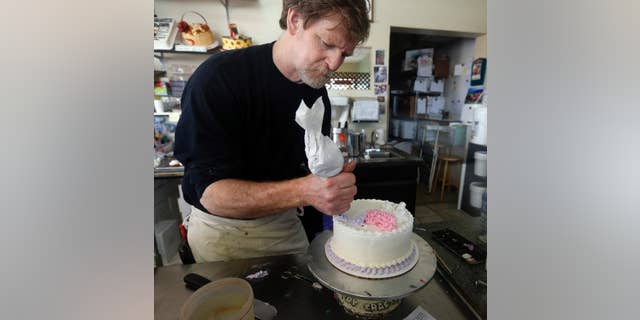 Masterpiece Cakeshop owner Jack Phillips decorates a cake inside his store, in Lakewood, Colo.
