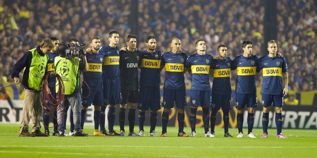 Argentina's Boca Juniors' players hold a minute of silence, in memory of an Argentine player who died earlier in the day, before a Copa Libertadores soccer match against River Plate in Buenos Aires, Argentina, Thursday, May 14, 2015. Emanuel Ortega, a 21-year-old fourth division soccer player, died after he was pushed by an opponent, and fell on concrete pillar during a fourth division game on May 3. Ortega died from his injury on Thursday. (AP Photo/Victor R. Caivano)
