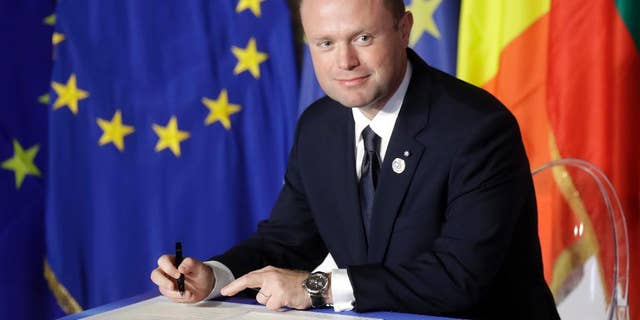 FILE - In this Saturday, March 25, 2017 file photo, Malta's Prime Minister Joseph Muscat signs a declaration during an EU summit meeting in the Palazzo dei Conservatori in Rome. Malta’s Prime Minister Joseph Muscat has called elections for June 3, a year early, to test his popularity amid a scandal swirling around his family. With the announcement on Monday, May 1, Muscat defied opposition demands for his resignation. (AP Photo/Alessandra Tarantino, file)