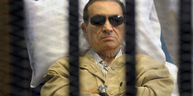 FILE - In this Saturday, June 2, 2012 file photo, Egypt's ex-President Hosni Mubarak lays on a gurney inside a barred cage in the police academy courthouse in Cairo, Egypt. An Egyptian appeals court on Sunday overturned Hosni Mubarak's life sentence and ordered a retrial of the ousted leader in the killing of hundreds of protesters, a ruling likely to further unsettle a nation still reeling from political turmoil and complicate the struggle of his Islamist successor to assert his authority. (AP Photo, File)