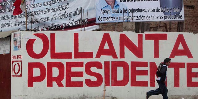 A boy runs in front of electoral propaganda of Peru's presidential candidate Ollanta Humala, of the Gana Peru party, in Lima, Peru, Monday, May 30, 2011. Humala will face Keiko Fujimori, daughter of former Peru's President Alberto Fujimori in a presidential runoff June 5. (AP Photo/Esteban Felix)