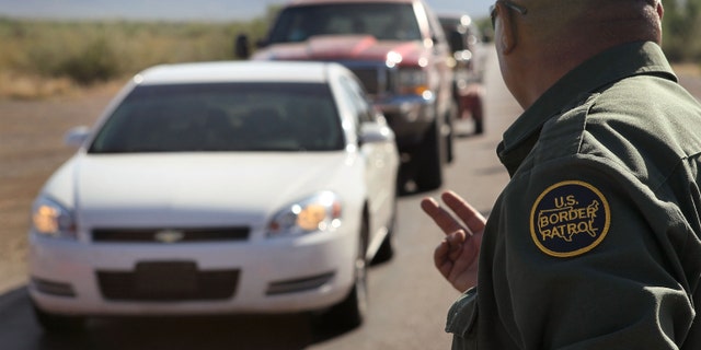SASABE, AZ - JUNE 01: A Border Patrol agent checks vehicles for illegal immigrants and contraband at a roadside checkpoint June 1, 2010 near Sasabe, Arizona. During the 2009 fiscal year 540,865 undocumented immigrants were apprehended entering the United States illegally along the Mexican border, 241,000 of those were captured in the 262 mile stretch of the border known as the Tucson Sector. (Photo by Scott Olson/Getty Images)