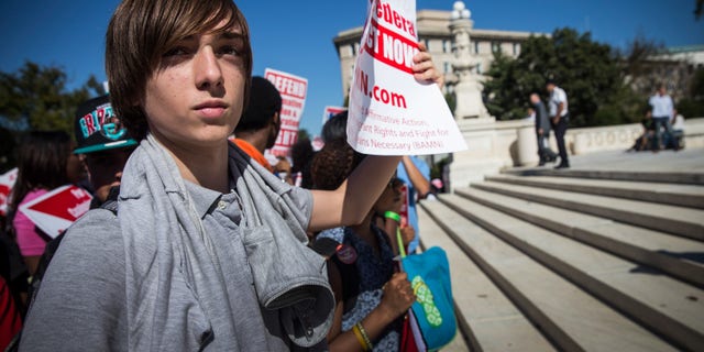 WASHINGTON, DC - OCTOBER 15: A boy protests in support of affirmative action, outside the Supreme Court during the hearing of "Schuette v. Coalition to Defend Affirmative Action" on October 15, 2013 in Washington, DC. The case revolves around affirmative action and whether or not states have the right to ban schools from using race as a consideration in school admissions. (Photo by Andrew Burton/Getty Images)