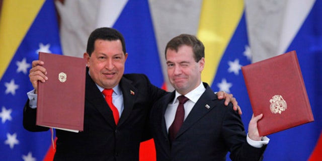 Russia's then-President Dmitry Medvedev, right, and his Venezuelan counterpart Hugo Chavez showing signed documents during a meeting in Moscow in 2010. (AP Photo/Alexander Zemlianichenko, File)