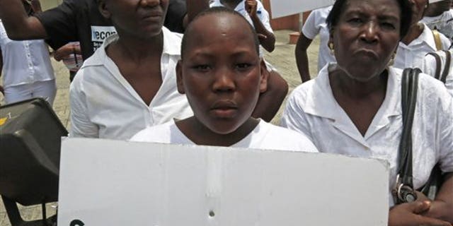 FILE - In this Aug. 12, 2013 file photo, a youth of Haitian descent holds a sign that reads in Spanish "I'm Dominican" during a protest demanding that President Danilo Medina stop the process to invalidate their birth certificates after authorities retained their ID cards, in Santo Domingo, Dominican Republic. The Dominican Republic's top court on Thursday, Sept. 26, 2013 stripped citizenship from thousands of people born to migrants who came illegally, a category that overwhelmingly includes Haitians brought in to work on farms. The decision cannot be appealed, and it affects all those born since 1929. (AP Photo/Ezequiel Abiu Lopez, File)