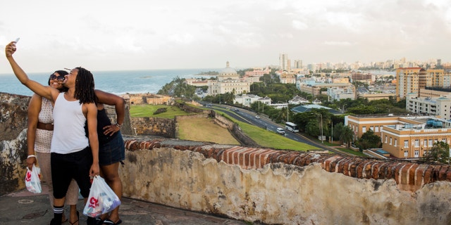 Friends pose for a photo in front of Old San Juan, the center for Puerto Rican tourism, on November 12, 2013.