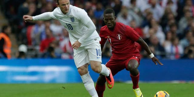 England's Wayne Rooney, left, competes for the ball with Peru's Luis Advincula during the international friendly soccer match between England and Peru at Wembley Stadium in London, Friday, May 30, 2014. (AP Photo/Matt Dunham)