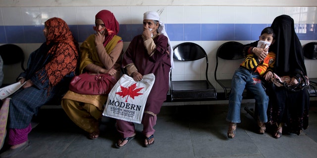 A child waits along with Kashmiri women for his turn to be examined at the Chest Disease Hospital on World Tuberculosis Day in Srinagar, India. Health officials are embarking on an ambitious plan to wipe out tuberculosis in children even though they don't know exactly how many cases there are.