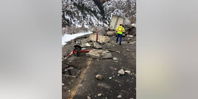 In this Tuesday, Feb. 16, 2016, photo provided by the Colorado Department of Transportation, state highway workers examine debris from a Monday rock slide on Interstate 70 in Glenwood Canyon in western Colorado.