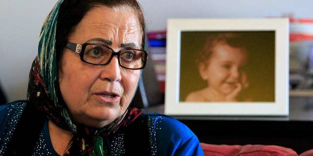 FILE - In this Thursday, April 7, 2016 file photo, Lebanese Ibtissam Berri speaks during an interview with The Associated Press as she sits next to a picture of her granddaughter Lahela al-Amin, at her home in the southern suburbs of Beirut, Lebanon. A state prosecutor in Lebanon is expected to file kidnapping charges against an Australian woman, an Australian TV crew, and others Monday for attempting to take the woman's two children away from their paternal grandmother and spirit them back to Australia. (AP Photo/Bilal Hussein, File)