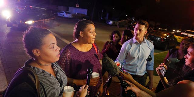 CORRECTS SPELLING TO SHERIE - Sherie Williams, left, and Theresa Williams, center, speak to the media as they leave the Baylor University Medical Center, Friday, July 8, 2016, in Dallas. Theresa Williams said her sister Shetamia Taylor, who was attending a rally with her four teenage sons in downtown Dallas, was shot in one of her legs. (AP Photo/Tony Gutierrez)