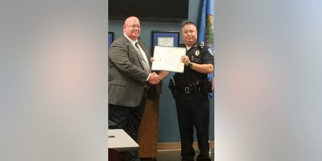 Thompson, right, receiving his certificate of commendation.