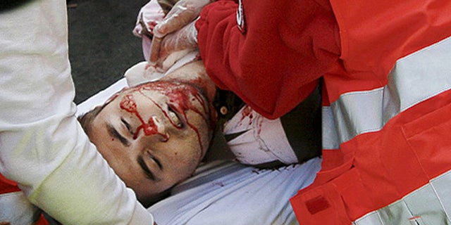July 10: A reveler is taken away on a stretcher after being gored in the neck by a bull during the run, in Pamplona. He later died at hospital.