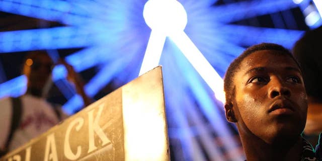 A demonstrator holds a sign during a protest in Atlanta on Friday, Sept. 23, 2016 in response to the police shooting deaths of Terence Crutch in Tulsa, Okla. and Keith Lamont Scott in Charlotte, N.C. (AP Photo/Branden Camp)