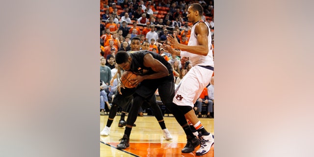 CORRECTS MISSOURI FIRST NAME TO TORREN FROM TORRENCE - Missouri's Torren Jones steps on the line as he rebounds a shot away from Auburn's Asauhn Dixon-Tatum, right, during the second half of an NCAA college basketball game on Saturday, Jan. 11, 2014, in Auburn, Ala. Missouri won 70-68. (AP Photo/Butch Dill)