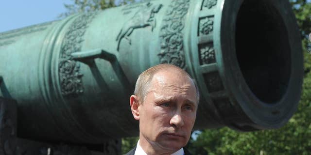 Russian President Vladimir Putin looks on during a meeting outside the Tzar Pushka ( Tzar Cannon) in Moscow's Kremlin, Russia, Thursday, July 31, 2014. Putin on Thursday presented state awards to cosmonauts, lawmakers, journalists and others. (AP Photo/RIA Novosti Kremlin, Mikhail Klimentyev, Presidential Press Service)