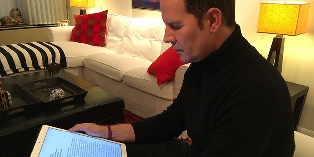 Feb. 4, 2018: Juan Carlos Cruz reads from his tablet during an interview with The Associated Press in Philadelphia.