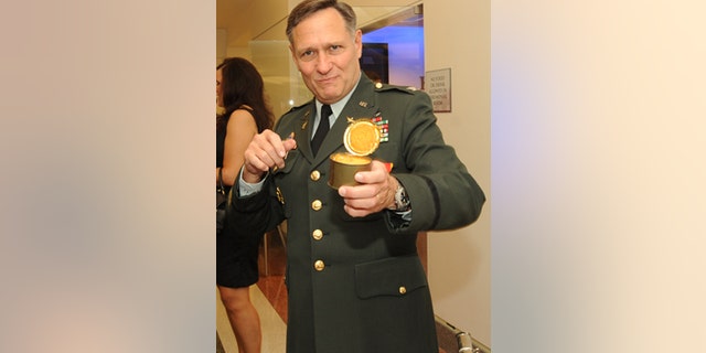 Col. Henry A. Moak Jr. digs in to an Army ration pound cake from 1973 at his retirement party.