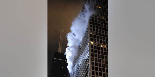 Dec. 10: Smoke pours from a fire on the 36th floor of a high-rise condo building near the John Hancock Center (left).