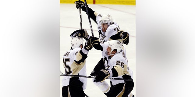 June 12: Pittsburgh Penguins Maxime Talbot, left, celebrates with Evgeni Malkin, from Russia, and Ruslan Fedotenko, from Ukraine, after scoring.