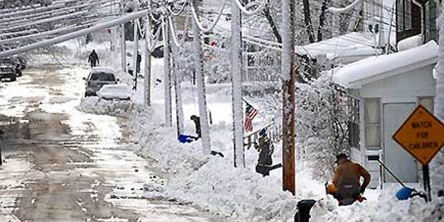 Dec. 9: Residents of Freeport, Ill., shovel a foot of snow on State Avenue. At least 17 have died in the severe winter storms across the U.S.