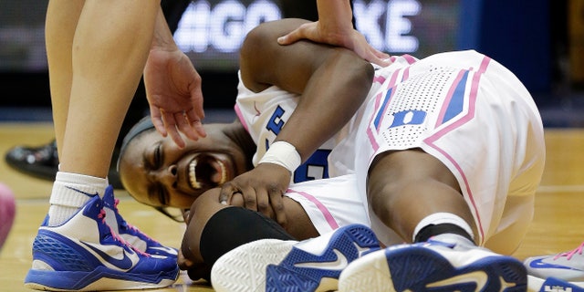 Duke's Chelsea Gray screams out as she grabs her knee following an injury during the first half of an NCAA college basketball game against Wake Forest in Durham, N.C., Sunday, Feb. 17, 2013. (AP Photo/Gerry Broome)