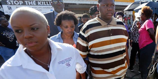July 13, 2016: Cameron Sterling, center, son of Alton Sterling, who was killed by Baton Rouge police last Tuesday, leaves after speaking to the media outside the the Triple S Food Mart, where his father was killed,in Baton Rouge, La. Cameron called his father a good man and urged protesters not to resort to violence.