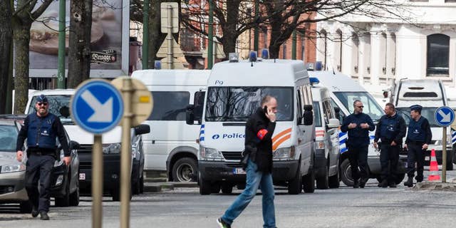 Police secure an area during a house search in the Etterbeek neighborhood in Brussels on Saturday April 9, 2016. The arrest Friday of six men suspected of links to the Brussels bombings, including the last known fugitive in last year's Paris attacks, raised new questions about the extent of the Islamic State cell believed to have carried out the intertwined attacks that left 162 people dead in two countries. (AP Photo/Geert Vanden Wijngaert)
