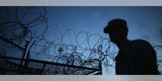 GUANTANAMO BAY, CUBA - JUNE 27: (EDITORS NOTE: Image has been reviewed by the U.S. Military prior to transmission.) A Public Affairs Officer escorts media through the currently closed Camp X-Ray which was the first detention facility to hold 'enemy combatants' at the U.S. Naval Station on June 27, 2013 in Guantanamo Bay, Cuba.The U.S. Naval Station at Guantanamo Bay, houses the American detention center for 'enemy combatants'. President Barack Obama has recently spoken again about closing the prison which has been used to hold prisoners from the invasion of Afghanistan and the war on terror since early 2002. (Photo by Joe Raedle/Getty Images)