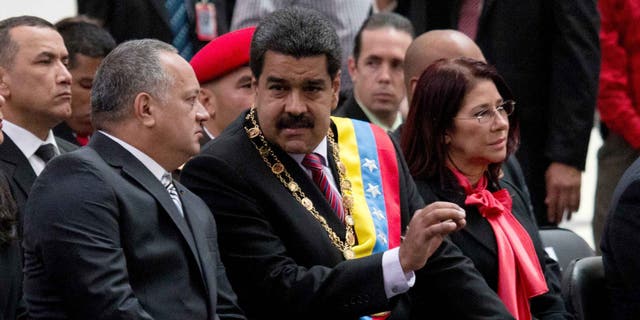 El presidente venezolano NicolÃ¡s Maduro, al centro, habla con Diosdado Cabello, presidente de la Asamblea Nacional, izquierda, durante una ceremonia para conmemorar el 185to aniversario de la muerte del hÃ©roe independentista SimÃ³n Bolivar en Caracas, Venezuela, el jueves 17 de diciembre de 2015. La mujer a la derecha es la primera dama Cilia Flores.