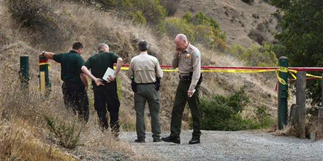 In this Tuesday, Oct. 6, 2015 photo, Marin County Sheriff's members investigate a homicide near the top of White's Hill on Old Railroad Grade near Fairfax, Calif.
