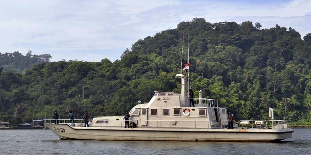 An Indonesian Navy boat carrying armed crew members patrol the waters near the prison island of Nusakambangan, background, where the planned executions of seven convicted foreign drug smugglers will be performed, in Cilacap, Central Java, Indonesia, Tuesday, Feb. 24, 2015. Indonesia is preparing the executions of the drug convicts from Australia, Brazil, France, Ghana, Nigeria and the Philippines. (AP Photo/Wagino)