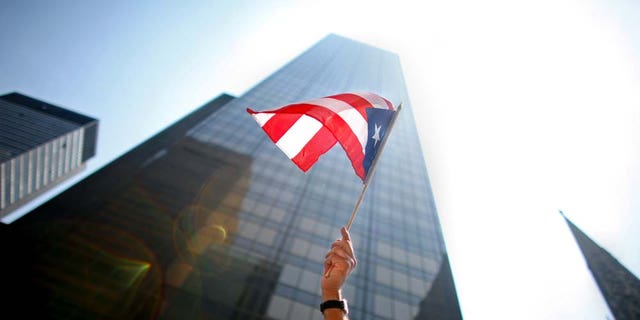 NEW YORK CITY - JUNE 8: A participant waves a flag in the annual Puerto Rico Day Parade June 8, 2008 in New York City. The parade honoring Puerto Ricans is an annual New York City tradition and takes place along Fifth Avenue. (Photo by Yana Paskova/Getty Images)