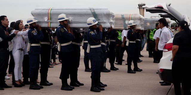 Coffins carrying LaMia flight crew members who died in a plane crash are carried by soldiers to a hearse at the Viru Viru airport in Santa Cruz, Bolivia, Friday, Dec. 2, 2016. Victims of this week's tragic air crash in the Andes were flown home Friday as Bolivia's president called for "drastic measures" against aviation officials who signed off on a flight plan that experts and even one of the charter airline's executives said should never have been attempted because of a possible fuel shortage. (AP Photo/Juan Karita)
