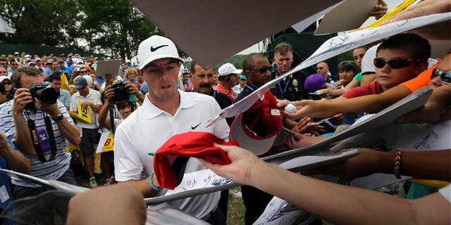 Rory McIlroy, of Northern Ireland, signs autographs after a practice round for the PGA Championship golf tournament at Valhalla Golf Club on Tuesday, Aug. 5, 2014, in Louisville, Ky. The tournament is set to begin on Thursday. (AP Photo/David J. Phillip)
