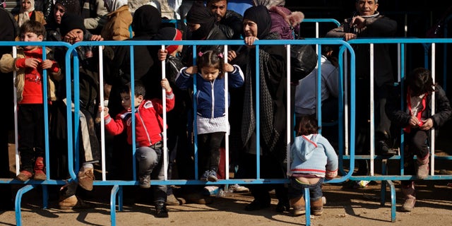 This Wednesday, Dec. 18, 2013 photo shows Syrian children passing time while waiting with their families at the U.N. refugee agency's registration center in Zahleh, in Lebanon's Bekaa Valley. With an endless surge of refugees now fighting the bitter winter cold, humanitarian organizations are struggling to find new ways to reach refugees with the timely, accurate information they need to survive, including the recruitment of refugees as volunteers so that people can access information from sources they can trust.(AP Photo/Maya Alleruzzo)