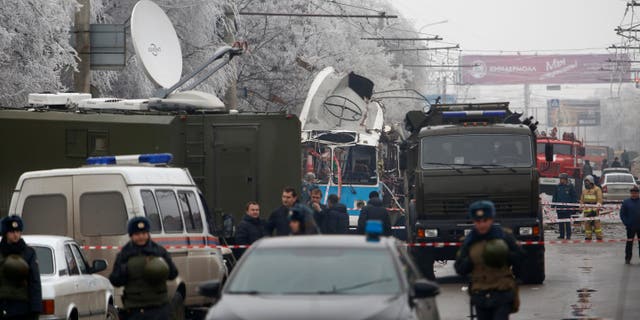 Military vehicles surround a wreckage of a trolleybus, in Volgograd, Russia, Monday, Dec. 30, 2013. A bomb blast tore through a trolleybus in the city of Volgograd on Monday morning, killing at least 10 people a day after a suicide bombing that killed at least 17 at the city's main railway station. Volgograd is about 650 kilometers (400 miles) northeast of Sochi, where the Olympics are to be held. (AP Photo/Denis Tyrin)