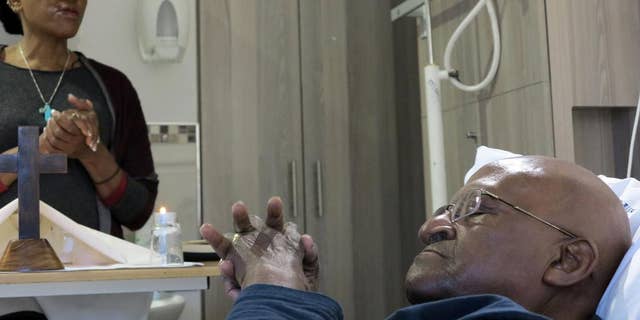 In this photo provided by Oryx Media shows retired Anglican Archbishop Desmond Tutu, praying in his hospital bed in Cape Town, South Africa Tuesday Aug. 4, 2015. Tutu left the hospital after being treated for an infection there since last month, his foundation said. (Benny Gool/Oryx Media via AP) CREDIT MANDATORY