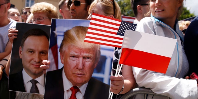 People holding portraits of President Trump and Polish President Andrzej Duda in July 2017.