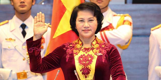 Nguyen Thi Kim Ngan takes the oath of office after being elected as chairwoman of the National Assembly in Hanoi, Vietnam Thursday, March 31, 2016. Vietnam's parliament on Thursday elected Ngan as its chairwoman, making her the first woman to lead the Communist-dominated legislature. (Thong Nhat/Vietnam News Agency via AP)