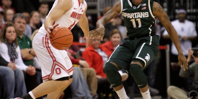 Ohio State's Aaron Craft, left, looks for an open pass as Michigan State's Keith Appling defends during the second half of an NCAA college basketball game Sunday, Feb. 24, 2013, in Columbus, Ohio. Ohio State beat Michigan State 68-60. (AP Photo/Jay LaPrete)