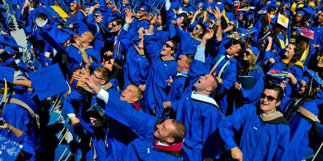 FILE - In this May 31, 2014 file photo, graduates throw their caps in the air in triumph at the University of Delaware's commencement ceremony in Newark, Del. Is someone in your family graduating from college this year? If so, here are a few things to keep in mind that might preserve your sanity on commencement day. (AP Photo/Emily Varisco)
