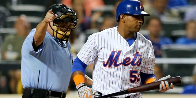 NEW YORK, NY - SEPTEMBER 15: Home plate umpire Dale Scott sends Yoenis Cespedes #52 of the New York Mets to first after he is hit by a pitch from Tom Koehler #34 of the Miami Marlins in the first inning on September 15, 2015 at Citi Field in the Flushing neighborhood of the Queens borough of New York City. (Photo by Elsa/Getty Images)