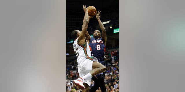 Atlanta Hawks' Shelvin Mack (8) shoots past Milwaukee Bucks' Chris Wright (15) during the first half of an NBA basketball game on Wednesday, April 16, 2014, in Milwaukee. (AP Photo/Morry Gash)
