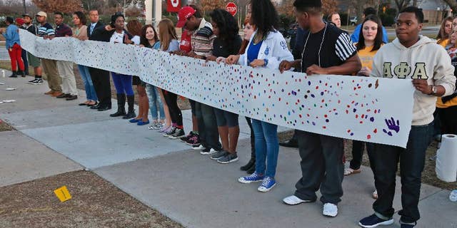 University of Oklahoma students hold a sign to be carried to the now closed University of Oklahoma's Sigma Alpha Epsilon fraternity house during a rally in Norman, Okla., Tuesday, March 10, 2015. The university's president expelled two students Tuesday after he said they were identified as leaders of a racist chant captured on video during a fraternity event. (AP Photo/Sue Ogrocki)